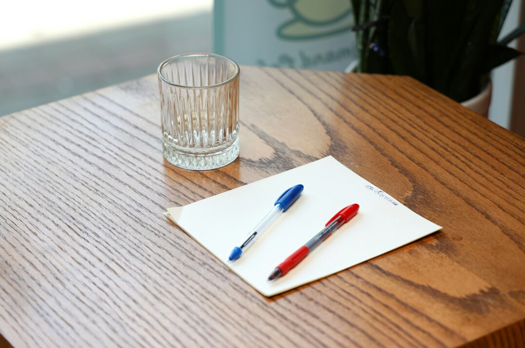 Overhead flatlay of a study desk with notebook, coffee cup and plant