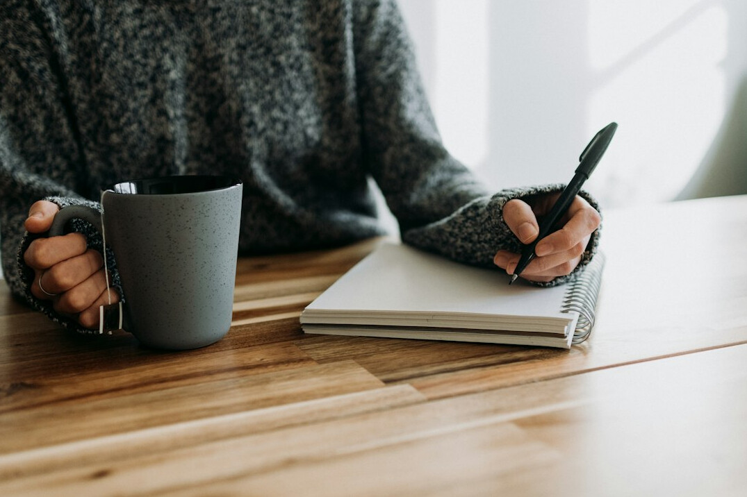 person writing in journal